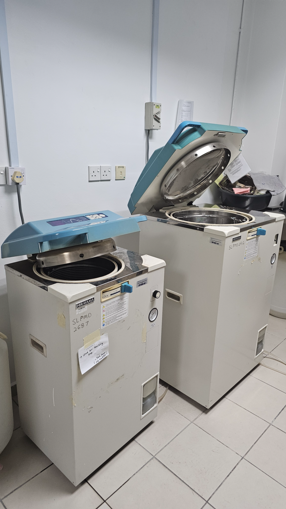 Two Hirayama top-loading autoclaves in room 3-4-14 with their lids open, the front one labelled as used for teaching preparation