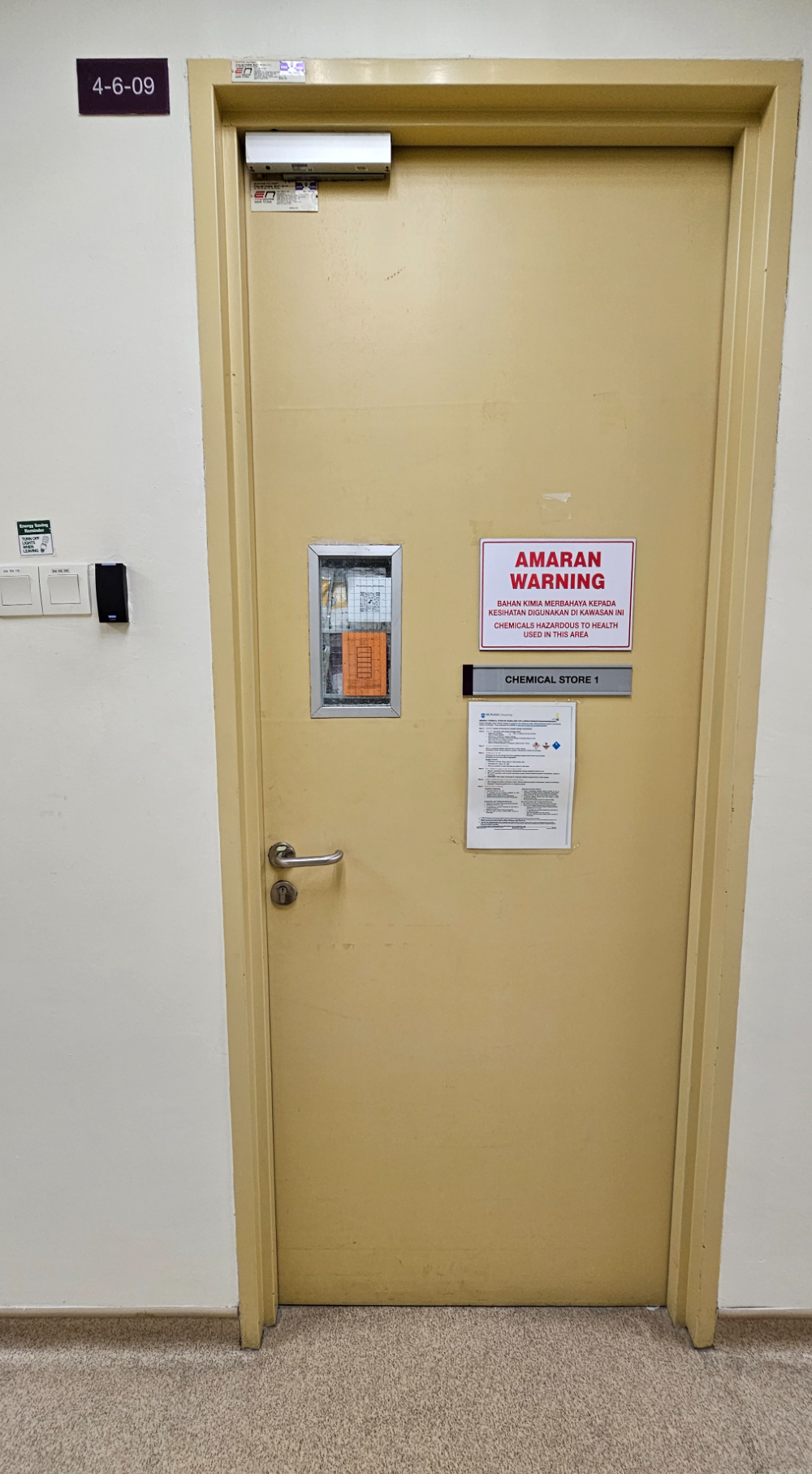 Door of room 4-6-09 signed Chemical Store 1, with the bilingual warning that chemicals hazardous to health are used in this area, and card access beside it
